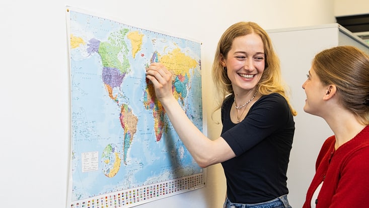 Two women looking at a map of the world